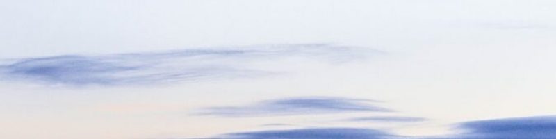 a person standing on a beach holding a surfboard